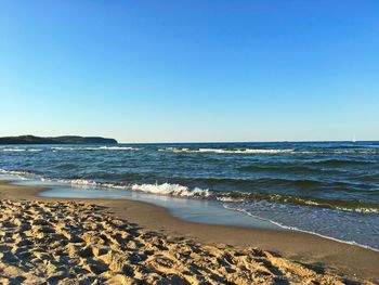 Scenic view of beach against blue sky