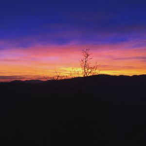 Silhouette landscape against sky at sunset