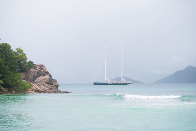 Sailboat sailing on sea against sky