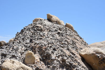 Low angle view of rock formation against clear blue sky