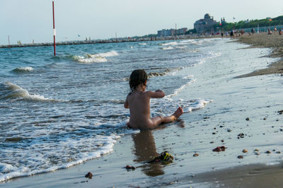 Naked girl sitting in sea