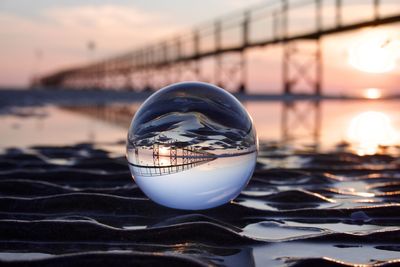 Close-up of crystal ball against sky