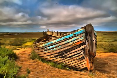 Wooden structure on field against cloudy sky