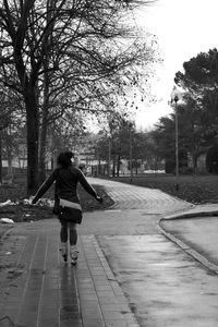 Rear view of woman walking on footpath