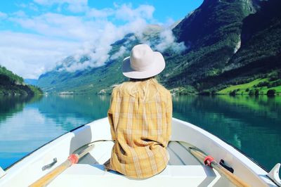 Rear view of man on boat in lake