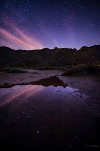 Scenic view of lake against sky at night