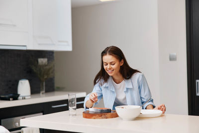 Young woman using mobile phone while sitting at home