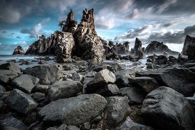 Rocks on sea shore against sky