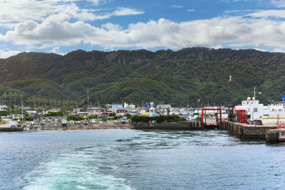 Scenic view of sea by buildings against sky