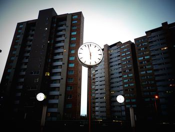 Low angle view of illuminated clock tower in city