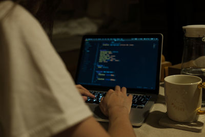 Midsection of man using laptop on table