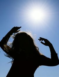 Low angle view of silhouette woman against clear sky