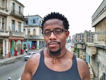 Portrait of man wearing eyeglasses against street in city