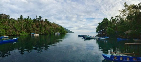 Boats moored in lake against sky