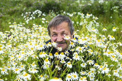 Senior man with flowers in field