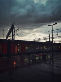 Bridge over wet street against sky during rainy season