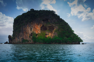 Rock formation by sea against sky