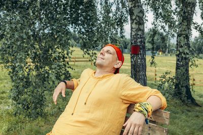 Portrait of young woman standing against trees