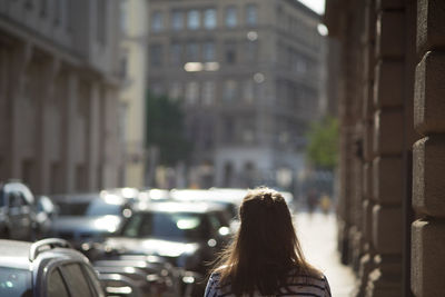 Rear view of woman walking on street in city