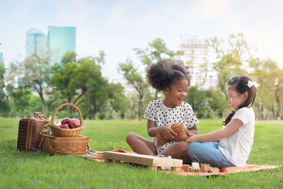Mother and daughter sitting on wicker basket