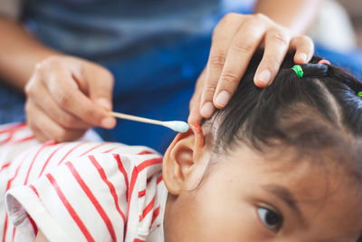 Nurse cleaning wound on girl ear