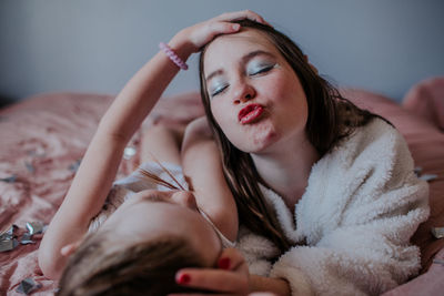 Sisters laying on bed making goofy faces together