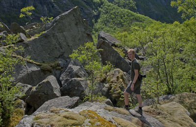 Woman standing on rock by mountain