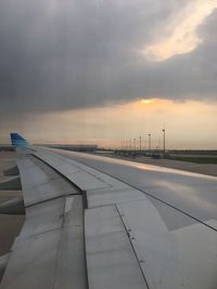 Airport runway against sky during sunset
