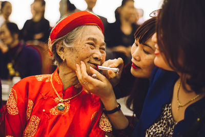 Close-up of woman applying lipstick on mother lips