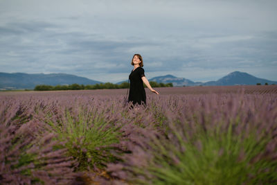 Woman standing on field against sky