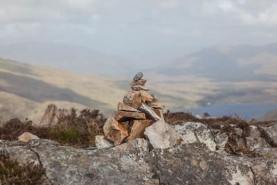 Close-up of sculpture on rock against sky