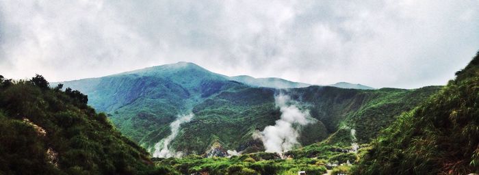 Scenic view of waterfall against sky