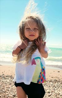 Portrait of girl with tousled hair standing at beach