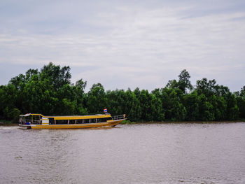 Boat sailing on river against sky