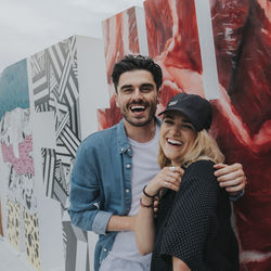 Portrait of smiling young couple standing outdoors