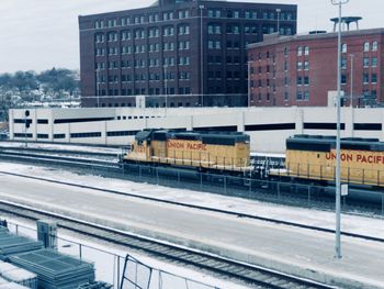 Railroad tracks by buildings in city