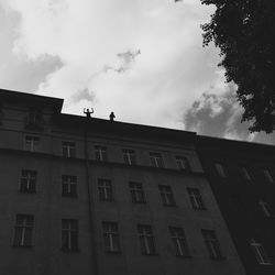 Low angle view of building against cloudy sky