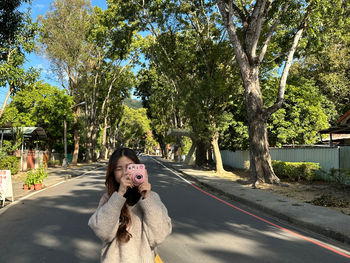 Side view of girl take a photo with polaroid