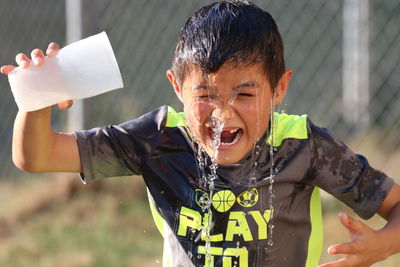 Boy pouring water over himself