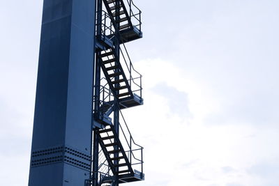 Low angle view of silhouette crane against sky