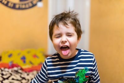 Cute boy with eyes closed sticking out tongue