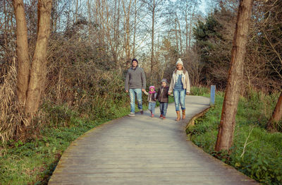 People walking on footpath by plants