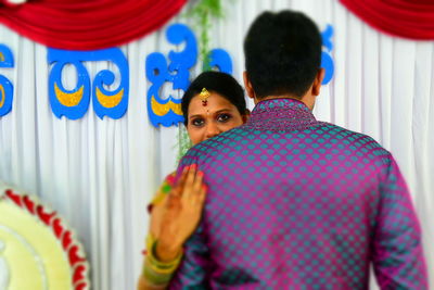 Portrait of young bride embracing groom during wedding ceremony