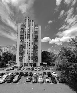 Cars on road by buildings against sky