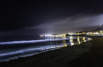 Scenic view of beach against sky at night