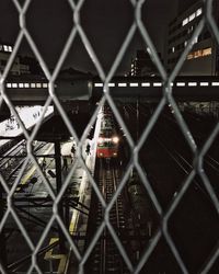 Close-up of chainlink fence at night