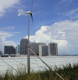 Wind turbines on field against sky