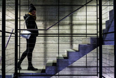 Side view of woman standing on tiled floor