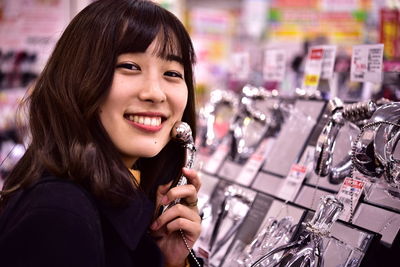 Close-up of smiling woman holding equipment at shopping mall