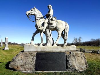 Low angle view of statue against clear blue sky